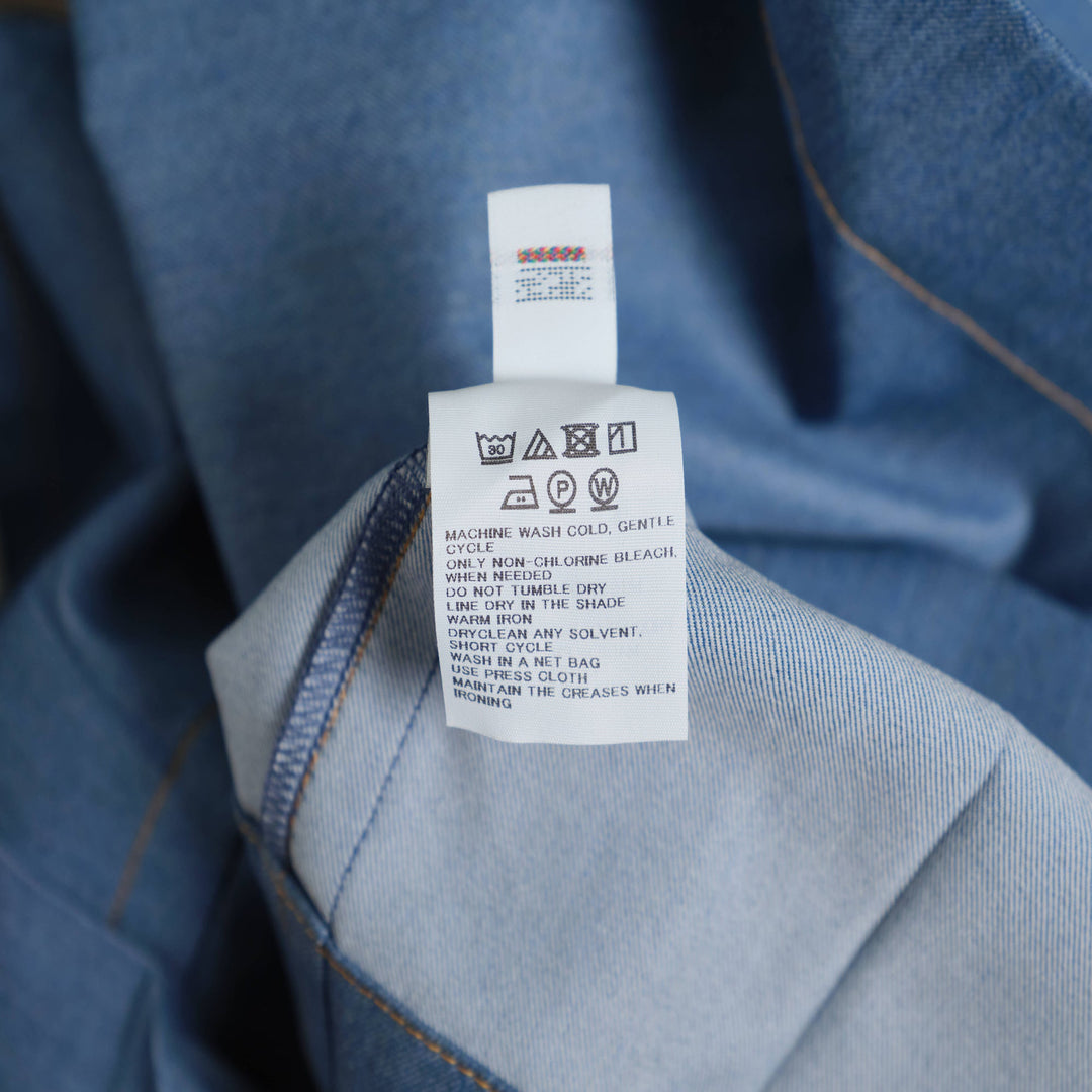 me Issey Miyake wide leg belted denim pants in medium blue with buckle closure and front pleats, flat lay view