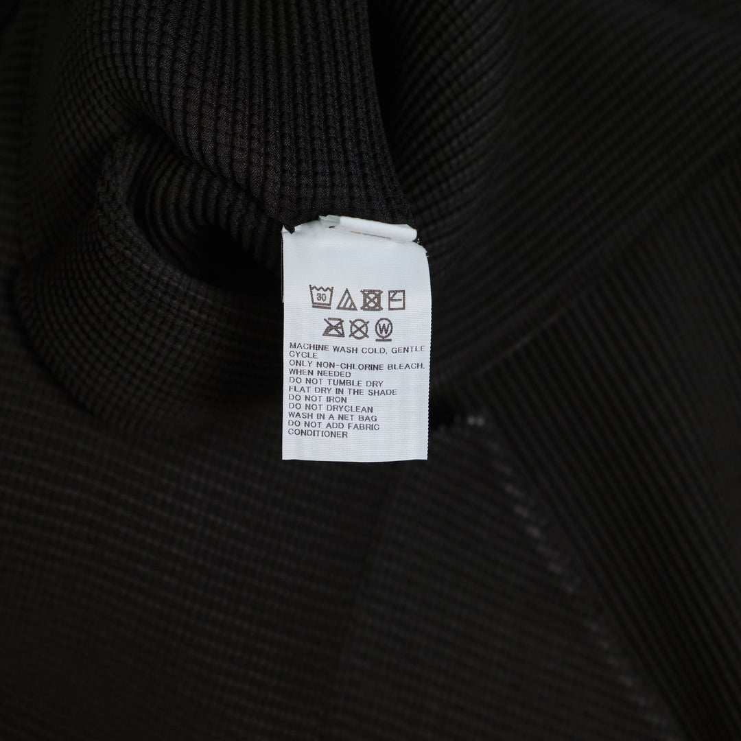 me Issey Miyake Stretch Pleats High Neck Top in black with short sleeves and structured turtleneck collar, flat lay on white background