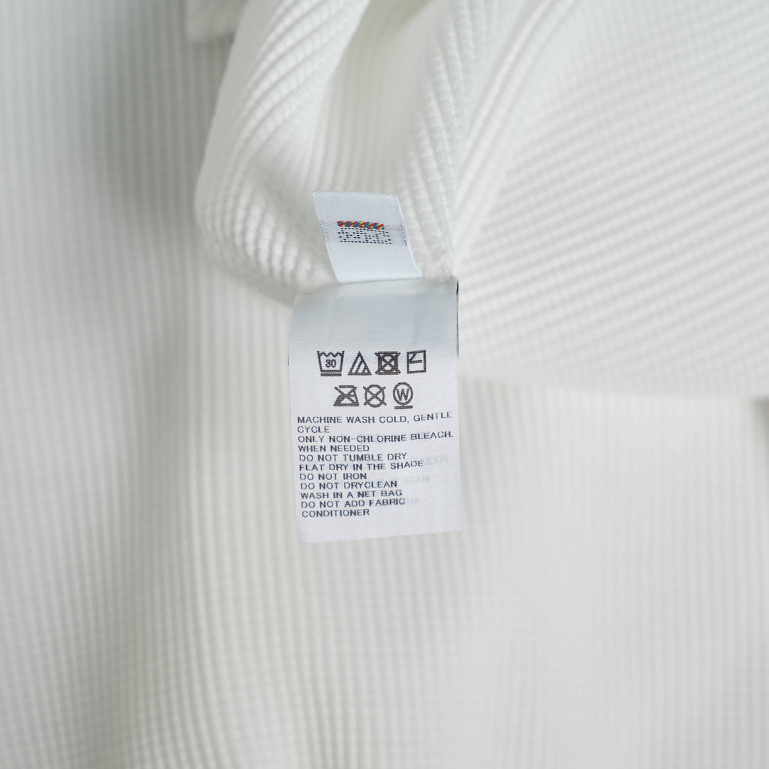 me Issey Miyake Stretch Pleats Round Neck Top in black, featuring all-over micro-pleating and short sleeves on a white background