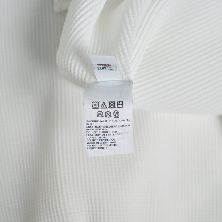 me Issey Miyake Stretch Pleats Round Neck Top in black, featuring all-over micro-pleating and short sleeves on a white background