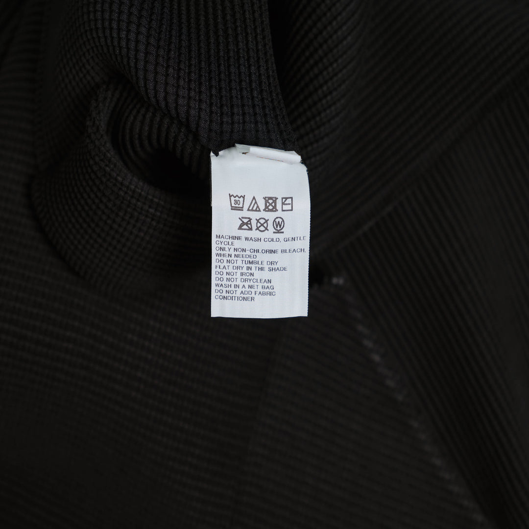 me Issey Miyake Stretch Pleats Basic Cardigan in black, open-front with spread collar and long sleeves, displayed flat on white background