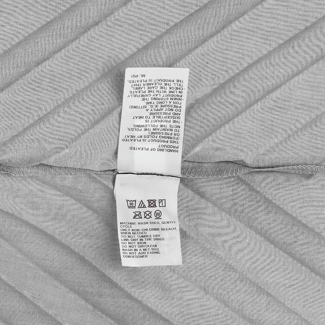 me Issey Miyake Angle Pleats Sleeveless Top in light grey with diagonal pleating and asymmetric hem, viewed from the front