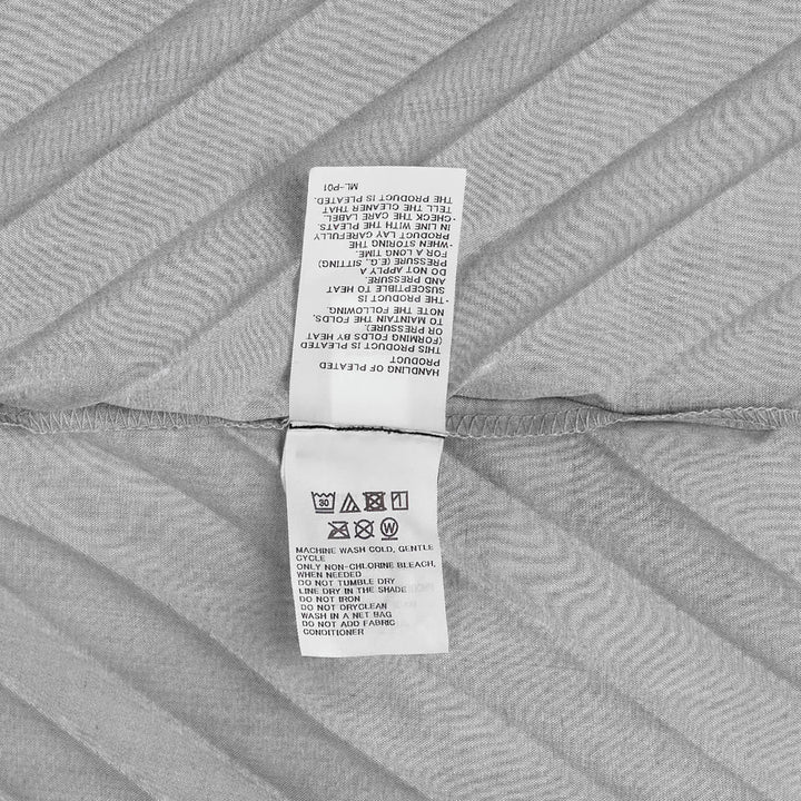 me Issey Miyake Angle Pleats Sleeveless Top in light grey with diagonal pleating and asymmetric hem, viewed from the front