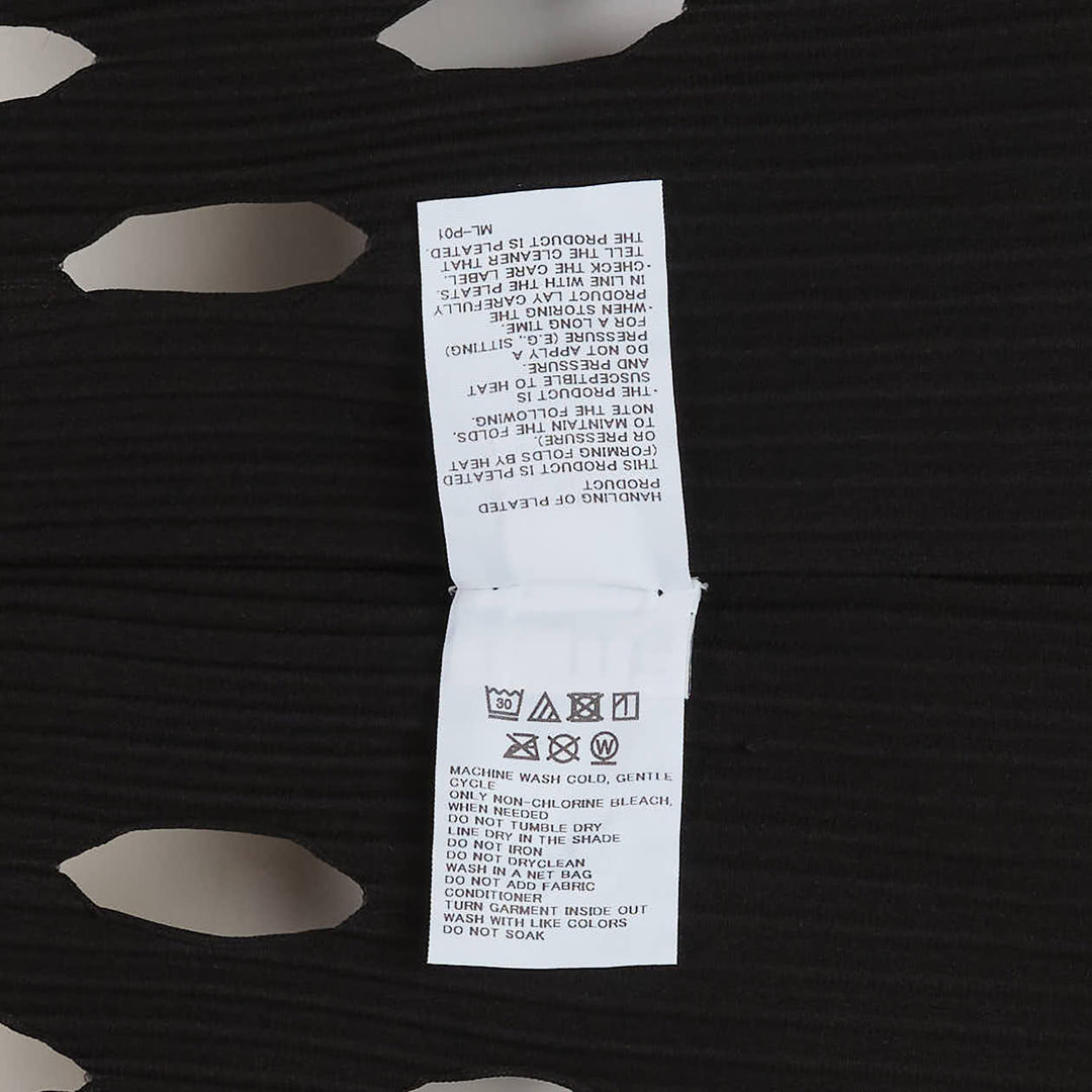 me Issey Miyake Aperture Pleats Dress in black — sleeveless pleated midi dress with oval cutout hem detail, front view on white background