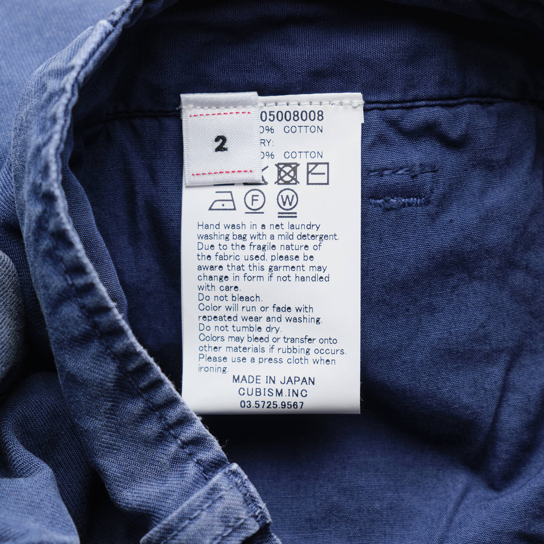 visvim Broader Chino Crash Shorts in washed navy blue with button fly, distressed cut-out detailing, and raw frayed hem