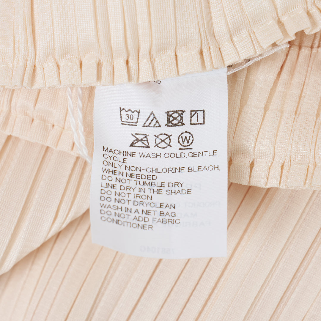 Pleats Please Issey Miyake Monthly Colors May Pants in soft blush pink with vertical micro-pleating and an elasticated waistband, straight-leg silhouette on a white background.