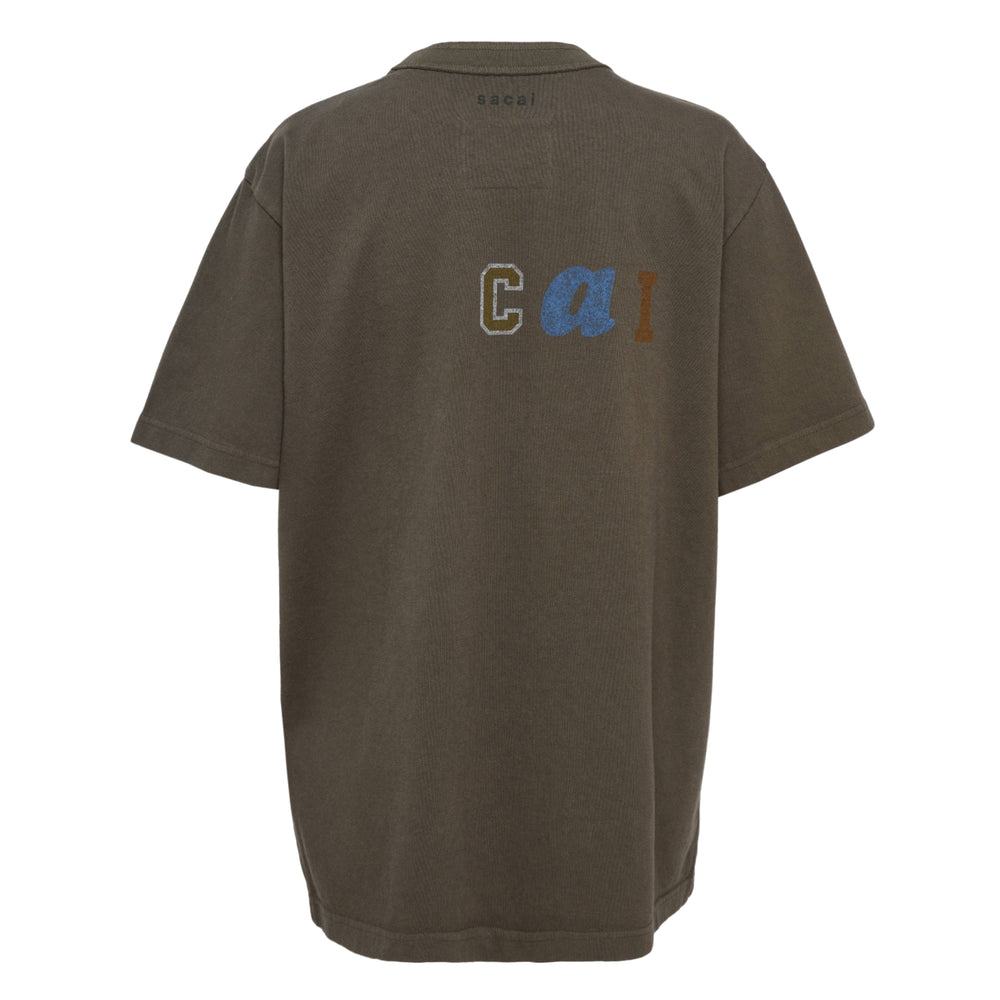 sacai Holiday Capsule oversized short sleeve tee in earthy olive brown with a faded tonal logo graphic on the chest, crew neckline, and dropped shoulders