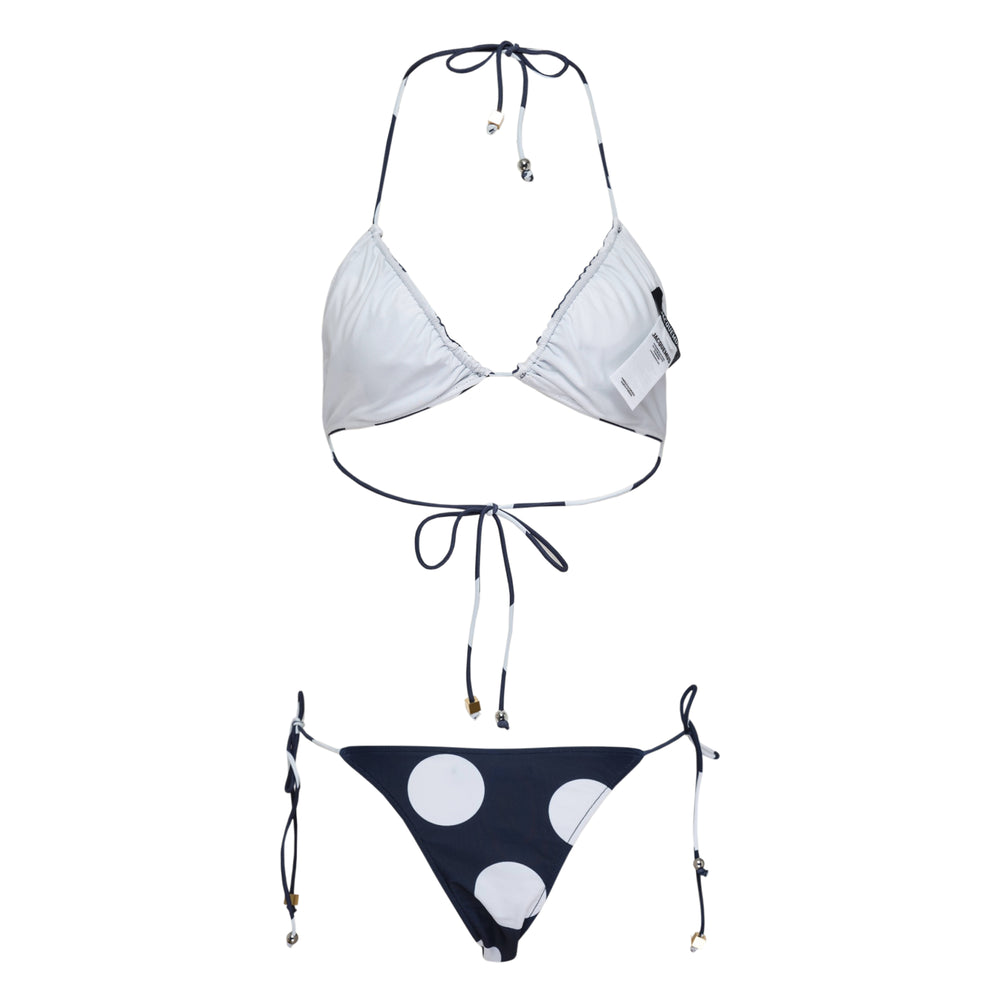 Jacquemus navy and white polka dot triangle bikini set with halter neck tie top and adjustable side-tie bottoms, featuring gold-tone hardware charms