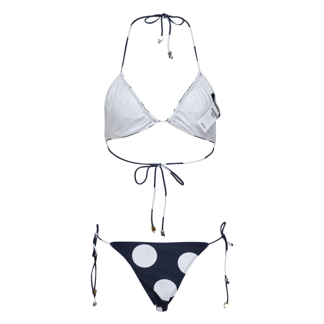 Jacquemus navy and white polka dot triangle bikini set with halter neck tie top and adjustable side-tie bottoms, featuring gold-tone hardware charms