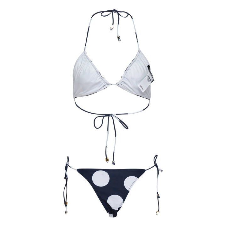Jacquemus navy and white polka dot triangle bikini set with halter neck tie top and adjustable side-tie bottoms, featuring gold-tone hardware charms