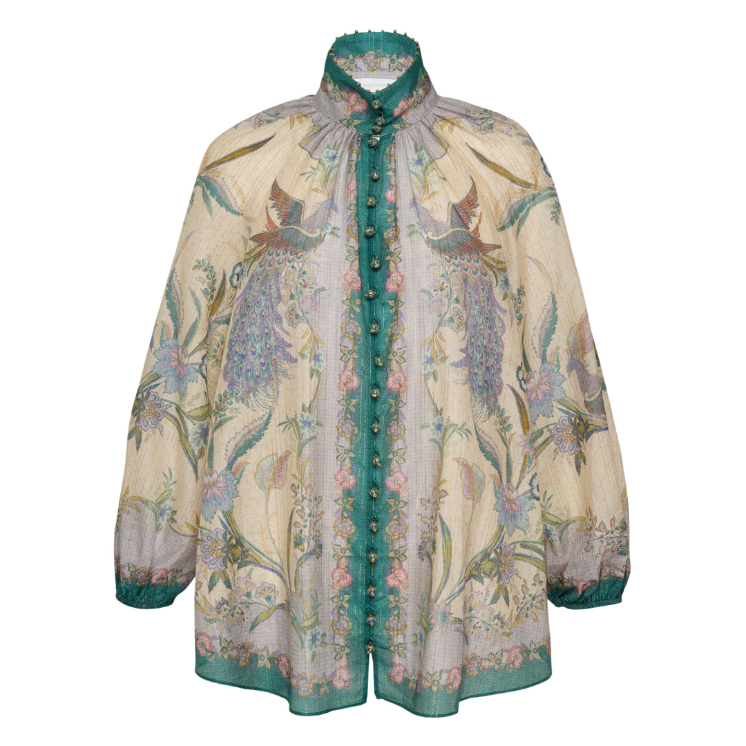 Zimmermann Indra Billow Blouse in cream with peacock and floral print, teal contrast placket with jewelled buttons, ruffled embellished collar, and billowy long sleeves with teal cuff trim