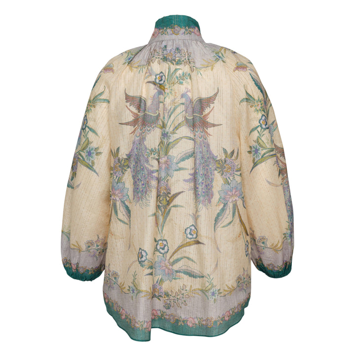 Zimmermann Indra Billow Blouse in cream with peacock and floral print, teal contrast placket with jewelled buttons, ruffled embellished collar, and billowy long sleeves with teal cuff trim