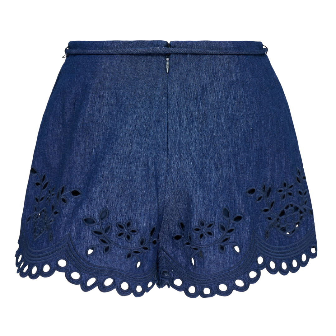 Zimmermann Mahon Broderie Denim Short in mid-wash indigo with floral eyelet embroidery, scalloped hem, and gold-tipped drawstring waist