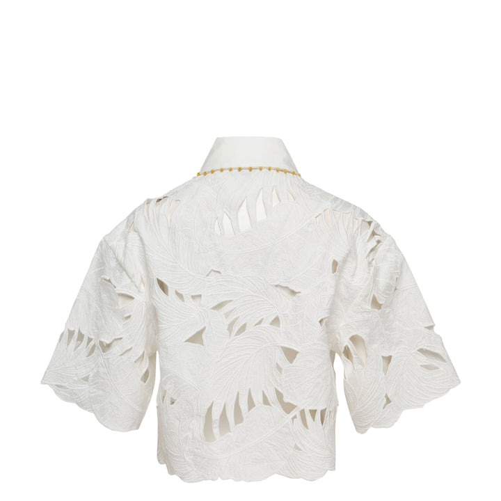 Zimmermann Mahon Embroidered Crop Shirt in ivory white with tropical leaf cutwork embroidery, gold beaded collar trim, and amber gold buttons