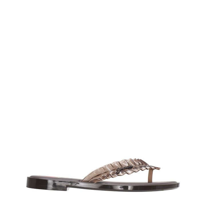 Ganni x Melissa ruffle flip flop sandal in chocolate brown semi-transparent PVC with layered ruffle strap and logo charm at the toe post, flat moulded sole, side profile view
