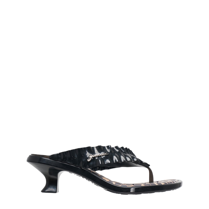 Ganni x Melissa black thong kitten heel sandal with ruched petal-texture strap, gold script logo hardware, leopard-print footbed, and sculptural low heel, shown in profile