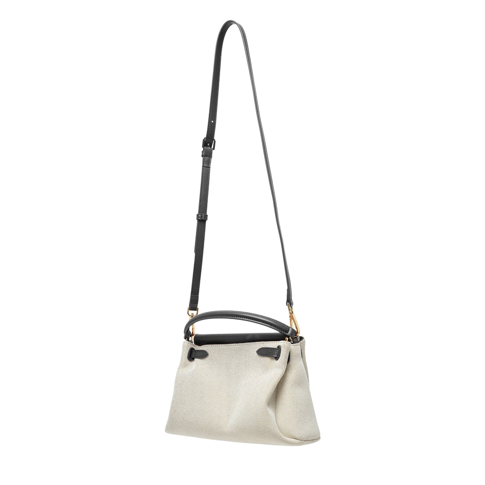 JW PEI Carmen Top Handle Bag in natural canvas with black leather trim, gold-tone turn-lock closure, arc top handle, and adjustable crossbody strap