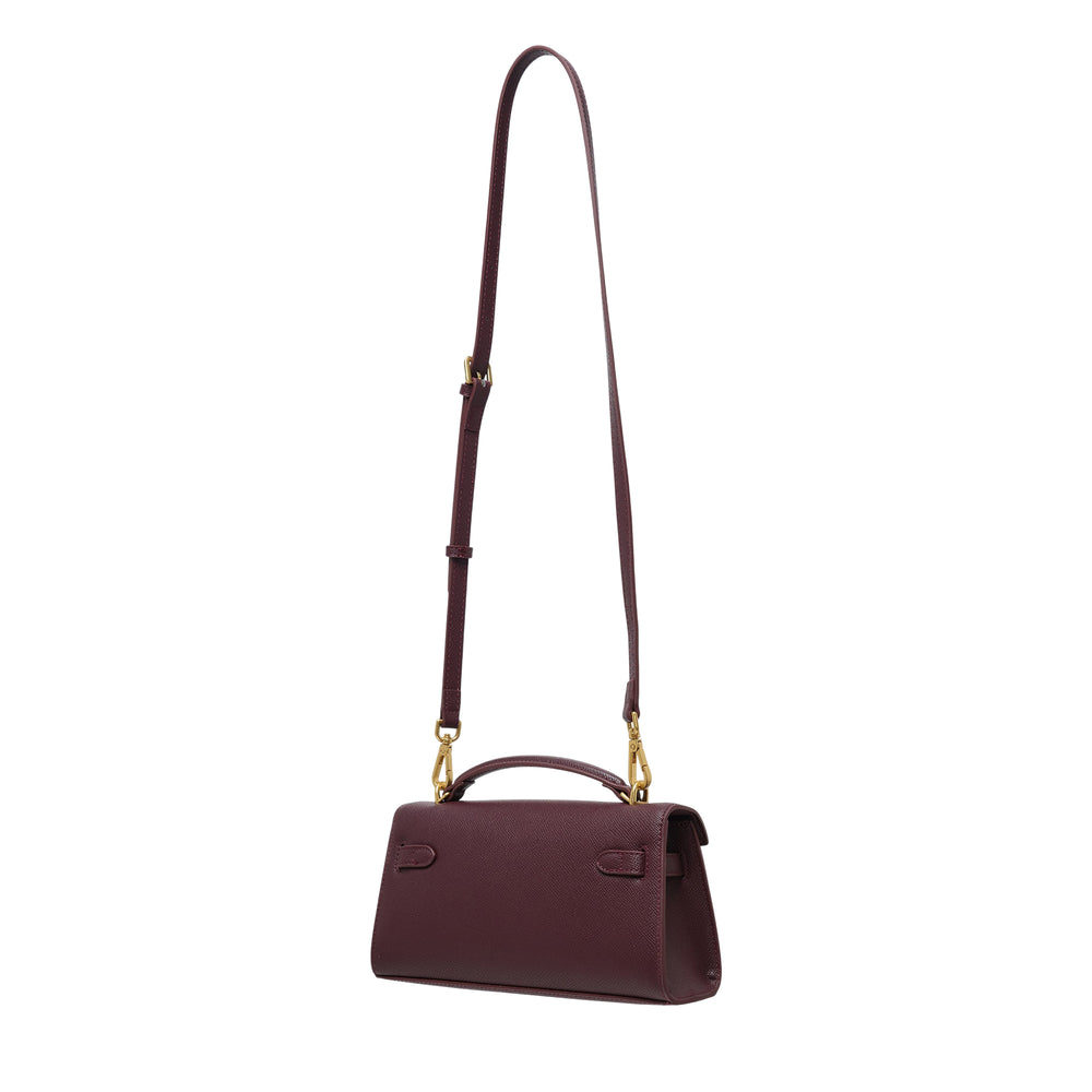 JW PEI Noor Top Handle Bag in deep burgundy cross-grain vegan leather with gold-tone turn-lock closure and adjustable crossbody strap, displayed on a white background