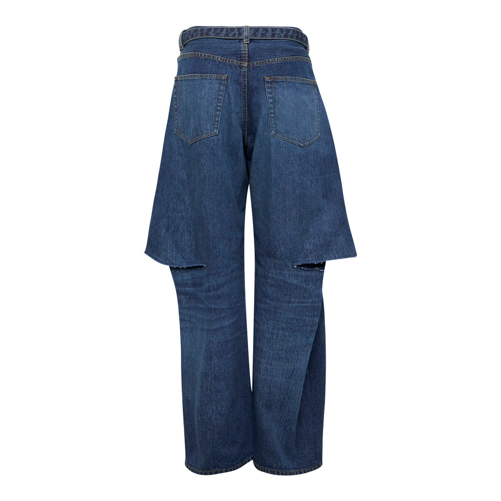 sacai dark grey washed wide-leg jeans with integrated denim overskirt panel, belted waist, and raw-cut knee openings, front view on white background