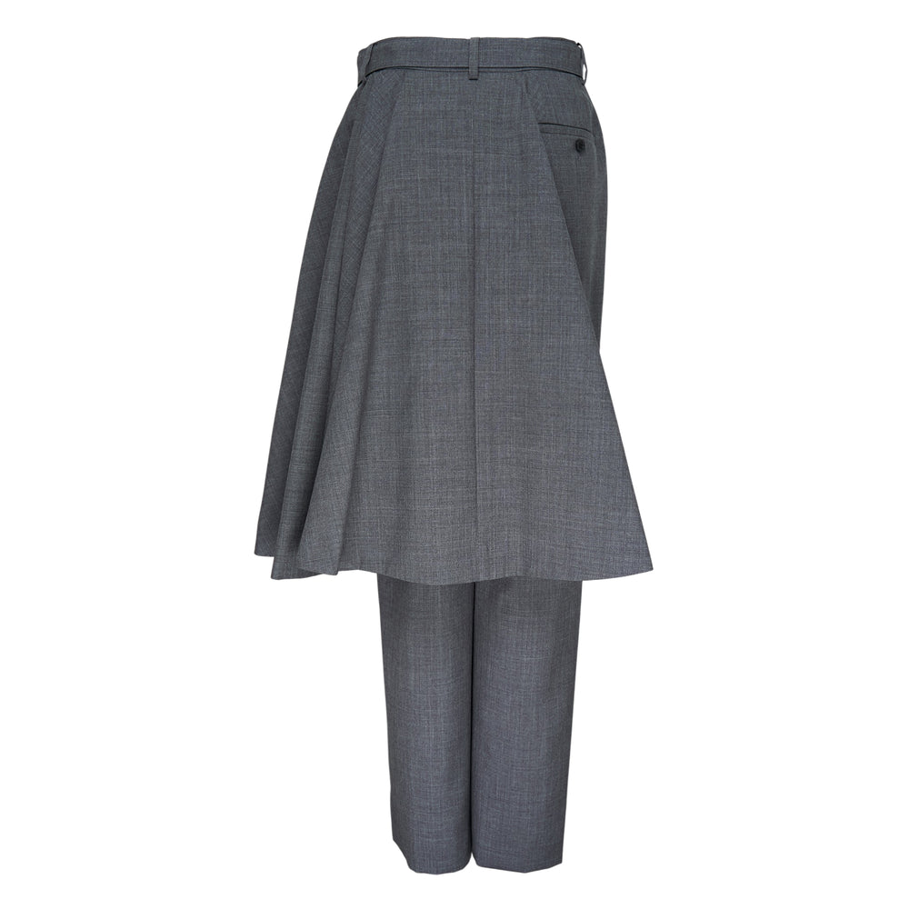 sacai black suiting pants with attached asymmetric pleated skirt overlay and belted waistband, shown from a side angle against a white background