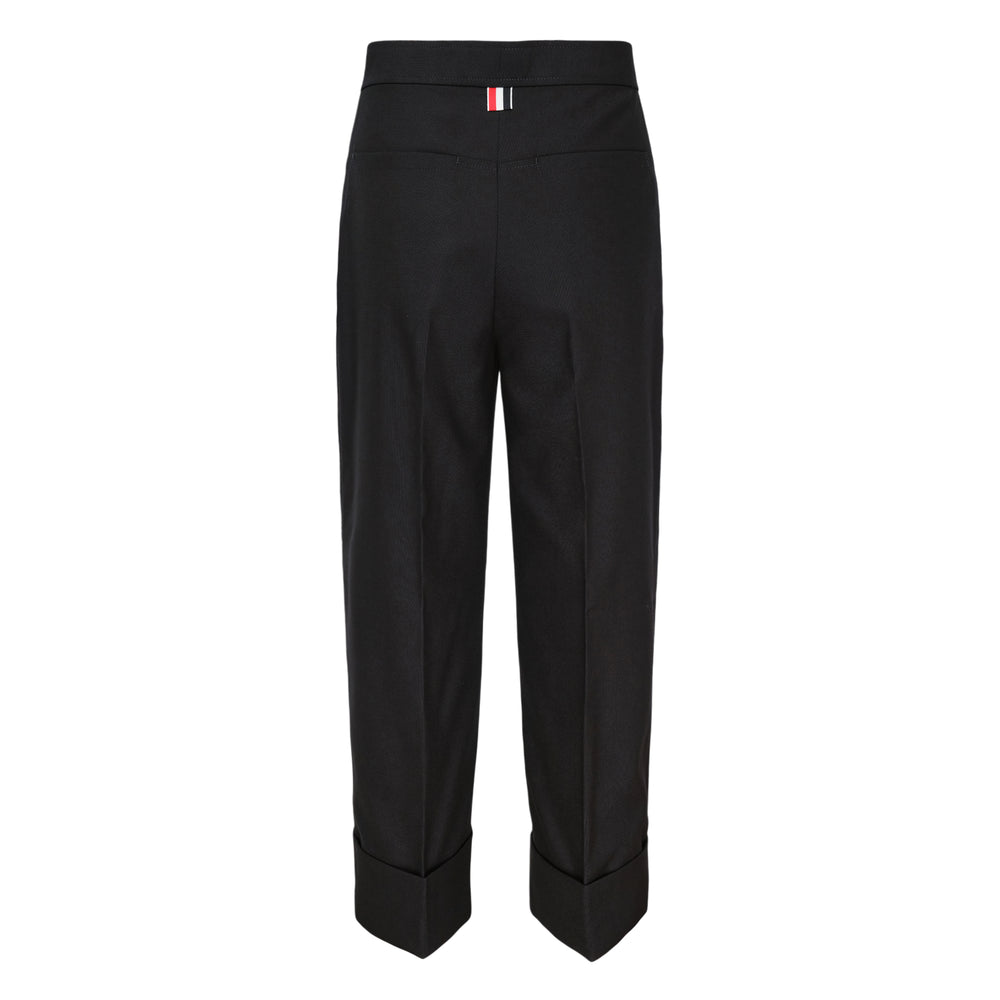 Thom Browne Cardigan Pocket Trousers care label showing 65% polyester and 35% cotton composition, set against the garment's signature red, white, and blue multistripe fabric - view 2