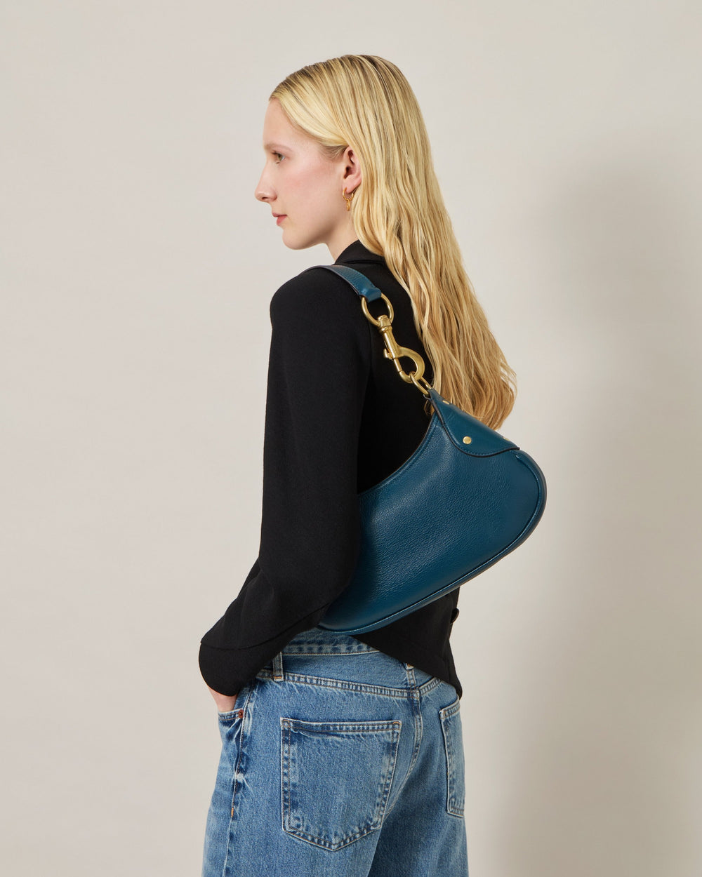 Mulberry Small Hackney Shoulder Bag in teal pebbled leather with an antique gold-tone bolt snap clasp on a single flat shoulder strap, curved crescent silhouette on a neutral background