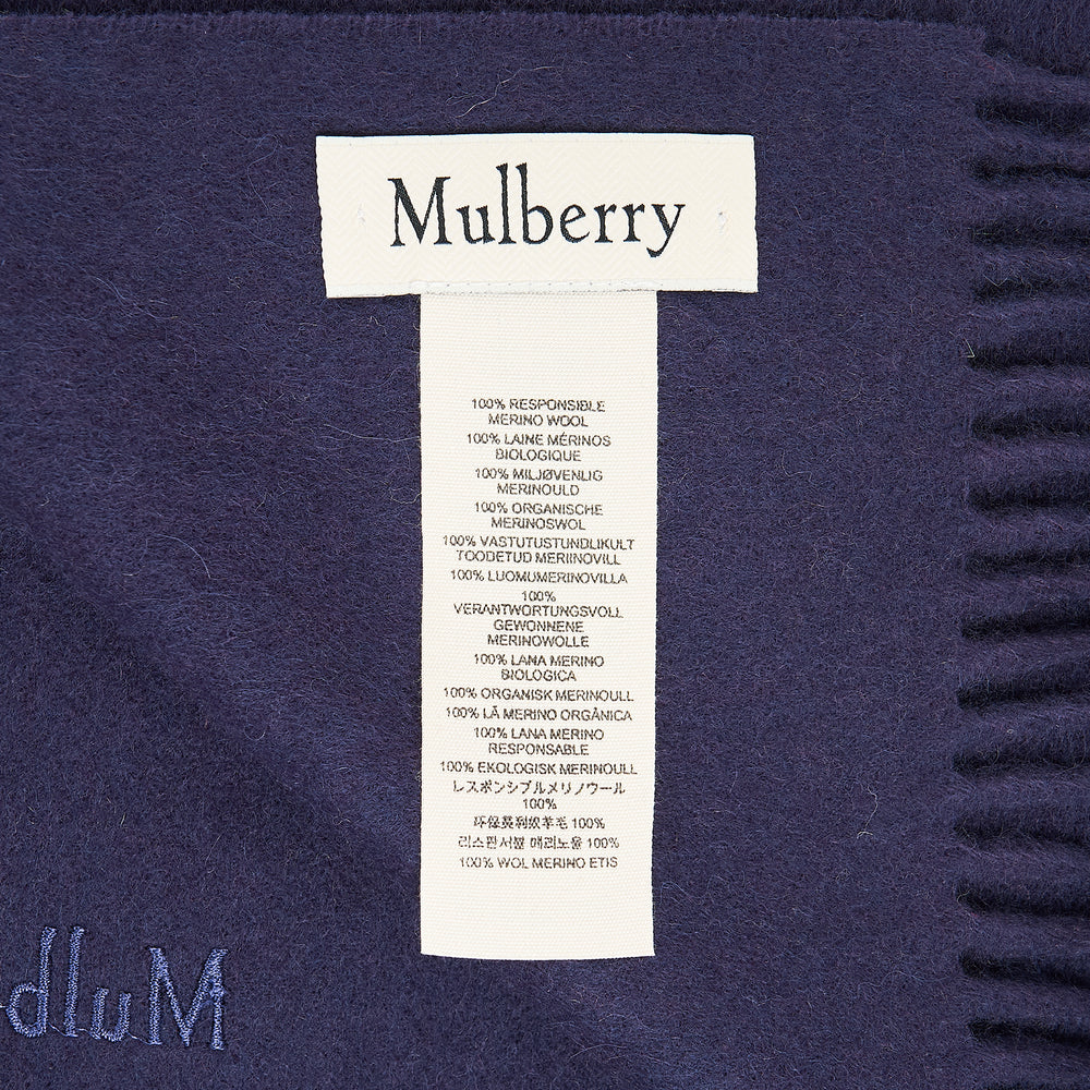 Mulberry Small Solid Merino Wool Scarf in tan with fringed ends and tonal embroidered branding, laid flat on a white background
