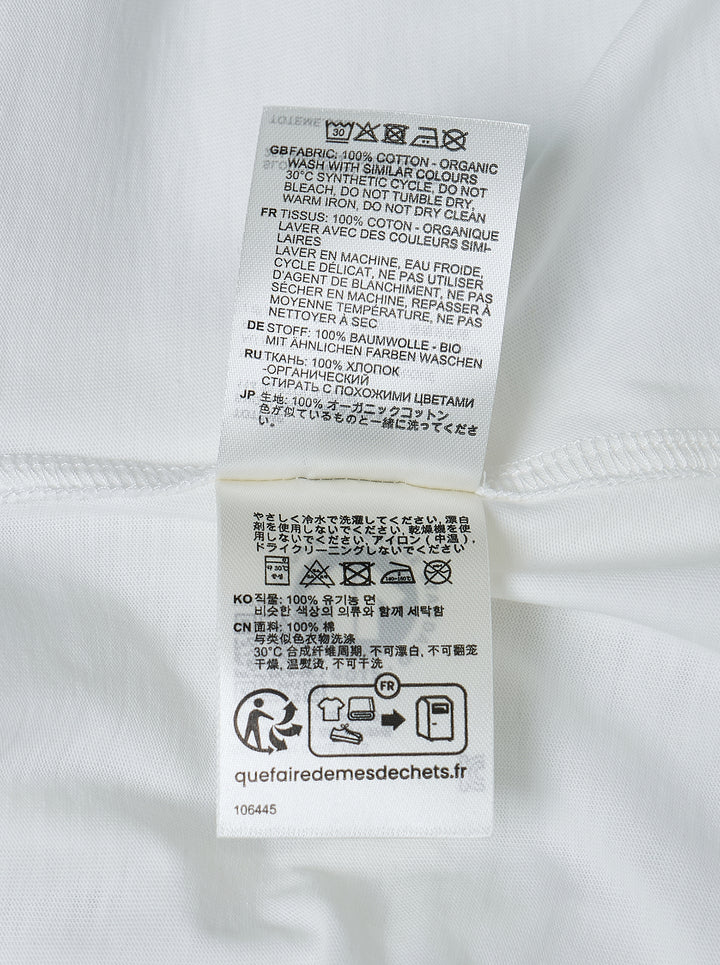 Totême Slouch Waist Jersey Top in white, featuring an oversized dropped-shoulder silhouette, centre-front seam, crew neckline, and short sleeves with folded cuffs, photographed flat on a white background - view 3