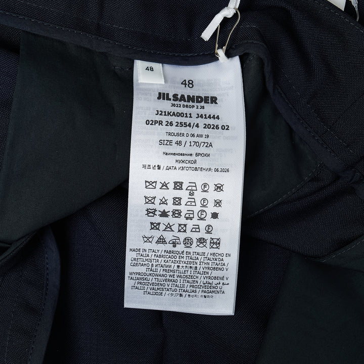 Jil Sander light brushed wool trousers in navy, featuring a high-rise waistband, pressed front creases, and a tapered straight-leg silhouette