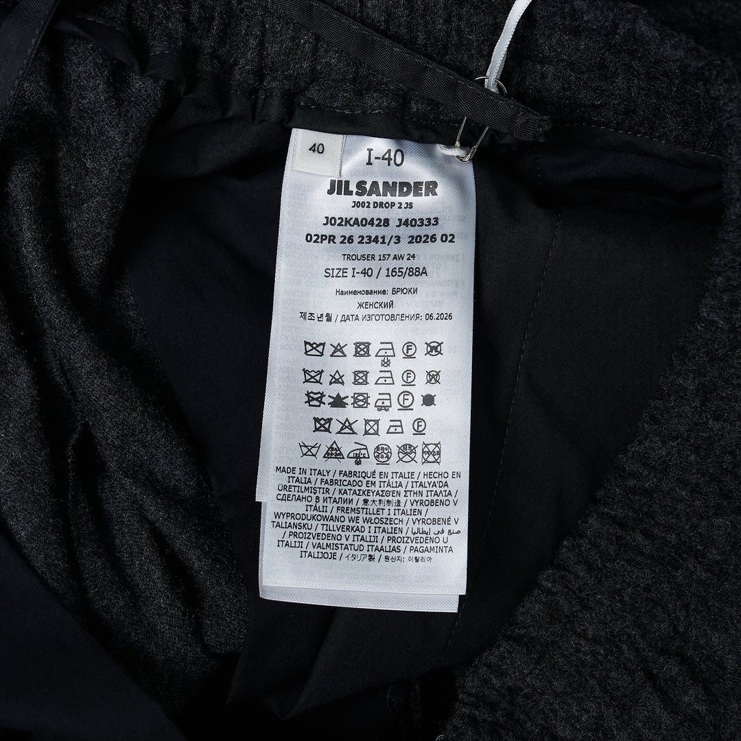 Jil Sander Light Merino wide-leg trousers in dark charcoal with elasticated waistband and clean straight-leg silhouette, front view