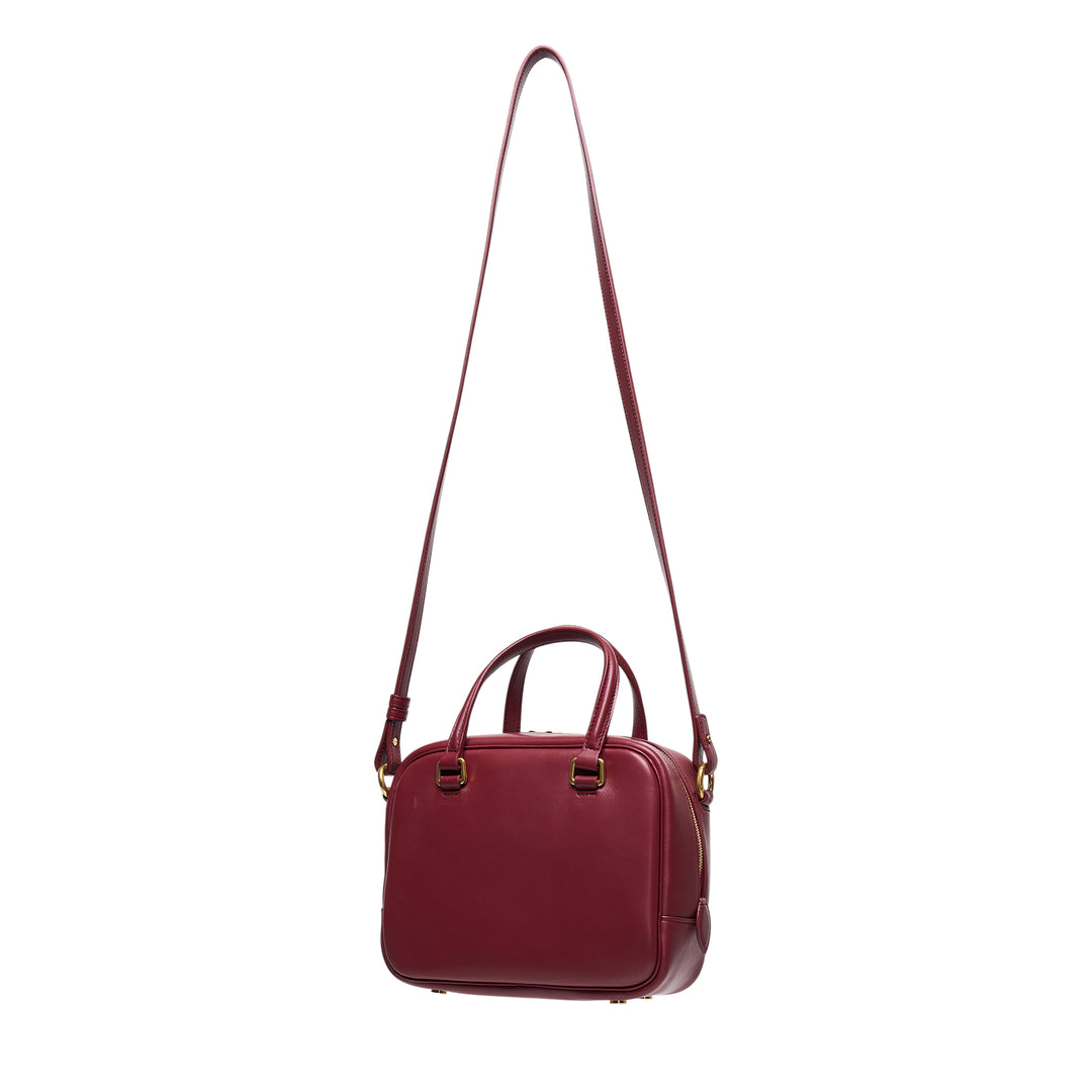 Jil Sander Vision Small burgundy nappa lambskin bowling bag with dual top handles, adjustable crossbody strap, and gold-tone hardware on a white background