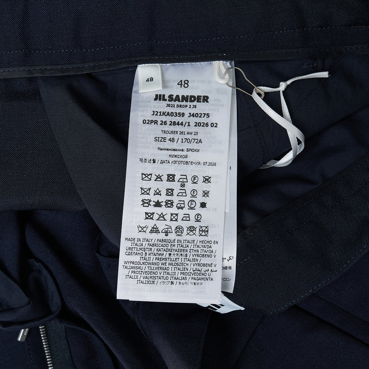Jil Sander navy fil-a-fil wool wide-leg trousers with high-rise waist, single forward pleat, and sharp pressed front crease, displayed flat on a white background