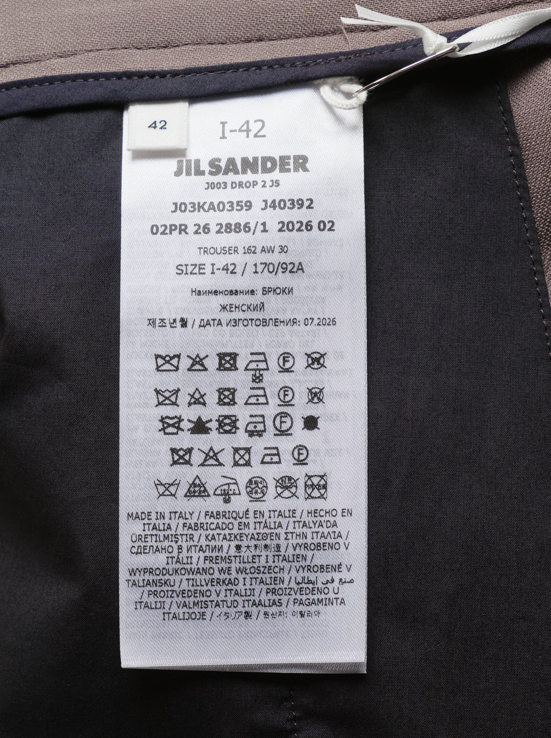 Jil Sander wide-leg stretch wool trousers in taupe with front creases, double-button waist, and belt loops, styled flat on a white background - view 3