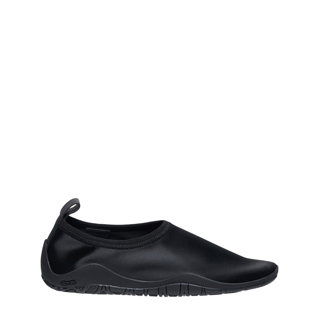 Jil Sander Elbe Slip On Satin Stretch water shoe in black, featuring a form-fitting stretch upper, rear pull tab, and Vibram rubber outsole, shown in profile view