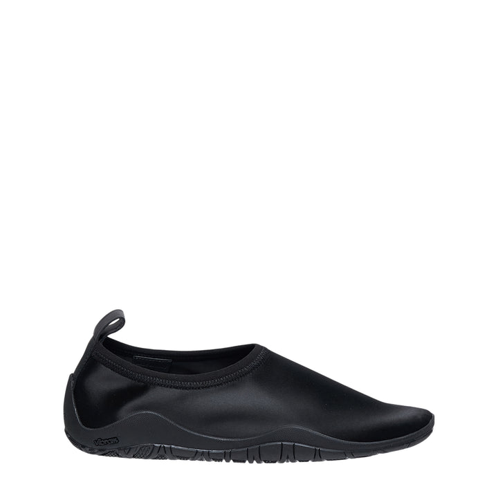 Jil Sander Elbe Slip On Satin Stretch water shoe in black, featuring a form-fitting stretch upper, rear pull tab, and Vibram rubber outsole, shown in profile view