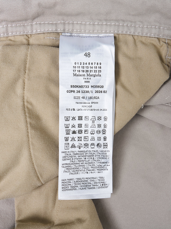 Maison Margiela stone cotton pants with a twisted seam and contrast tan tape trim, shown from the front - view 4