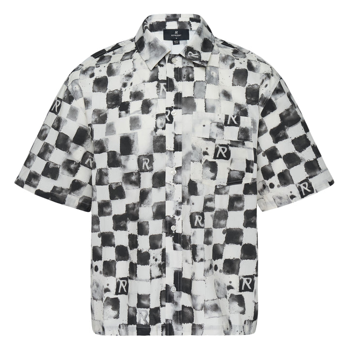 Represent Pool Side Short Sleeve Shirt in a distressed monochrome checkerboard print with repeat 'R' monogram square patches, dual chest pockets, and button-through front fastening, laid flat on a white background.