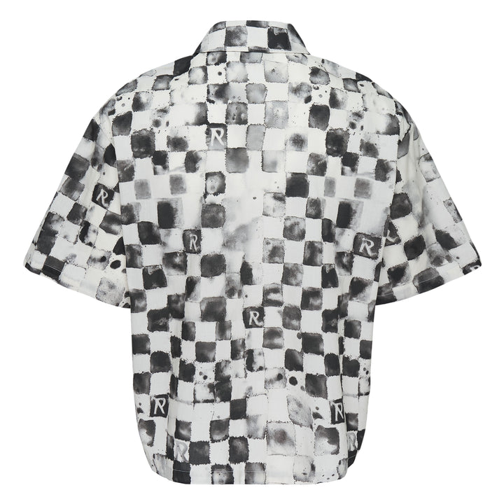 Represent Pool Side Short Sleeve Shirt in a distressed monochrome checkerboard print with repeat 'R' monogram square patches, dual chest pockets, and button-through front fastening, laid flat on a white background.