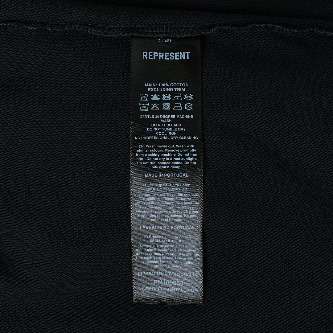 Back view of the Represent Duality Forever Graphic Tee in washed black, featuring gothic blackletter typography, winged lettering, and a mirrored skull heart graphic on a distressed oversized tee