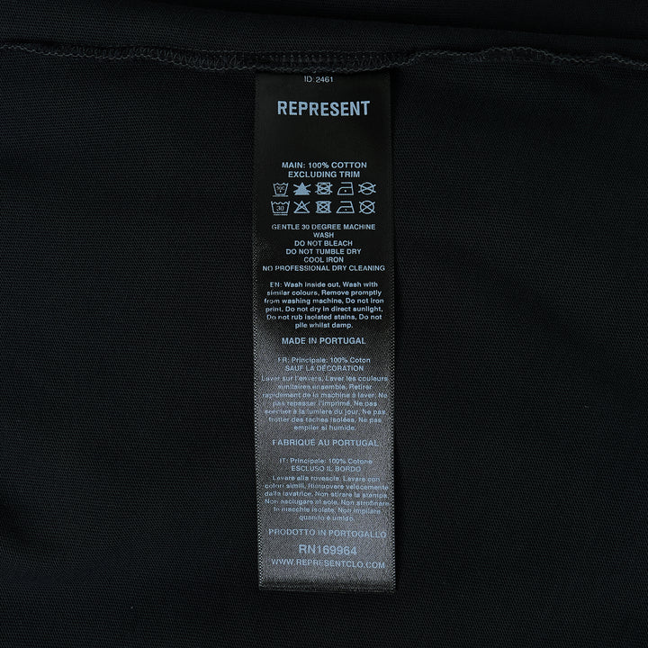 Back view of the Represent Duality Forever Graphic Tee in washed black, featuring gothic blackletter typography, winged lettering, and a mirrored skull heart graphic on a distressed oversized tee