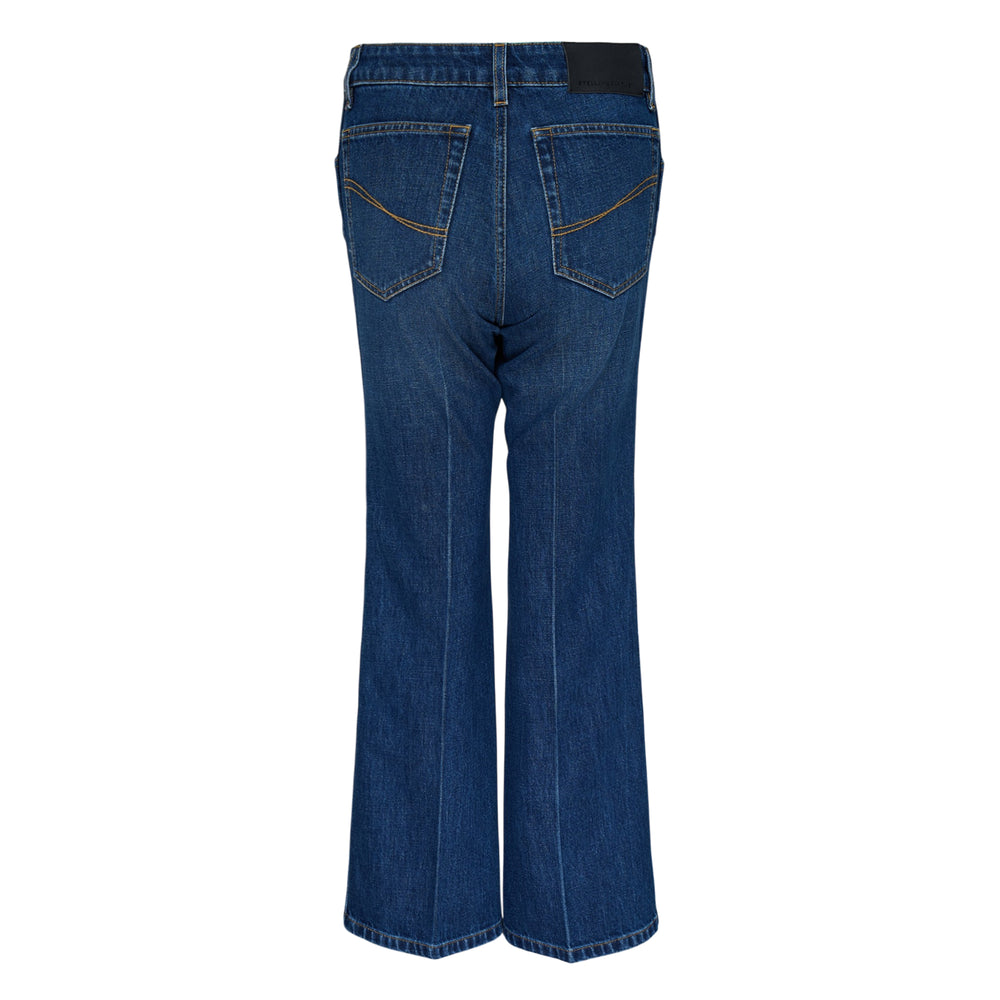 Stella McCartney Cropped Kick Jeans in mid-wash blue denim with gold-tone chain charm at the waistband and wide flared leg, front view