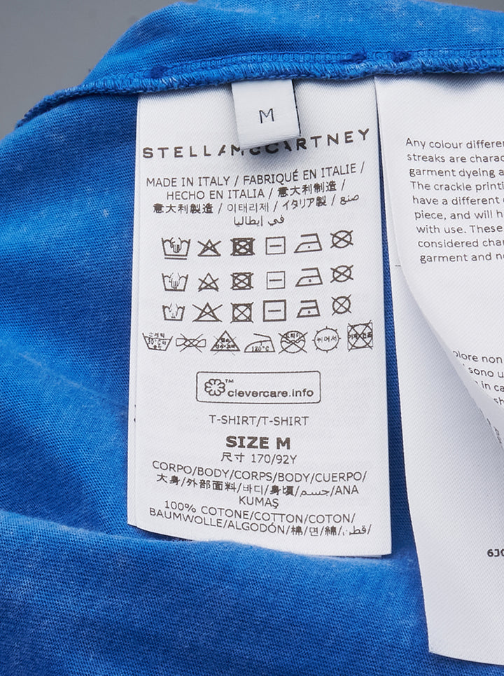 Stella McCartney Abbey Road Boyfriend Tee in acid-washed cobalt blue with a circular psychedelic logo graphic in white and aqua, crew neckline and short sleeves, front view on white background - view 3