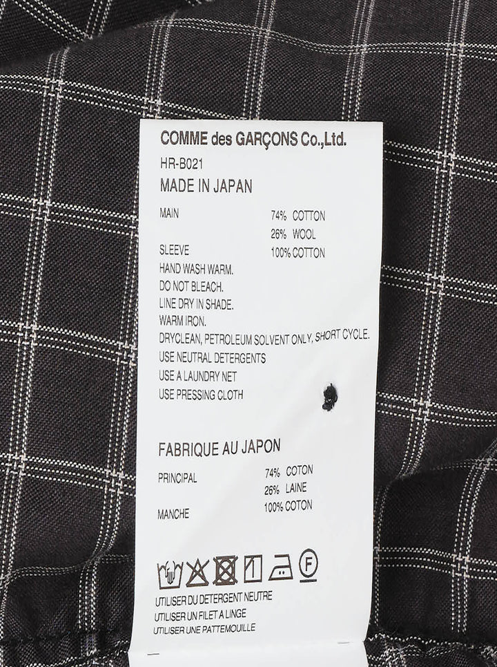 Comme des Garçons Homme long sleeve shirt with dark windowpane check cotton body and contrast solid black cotton broad cloth sleeves, shown flat on a white background - view 3