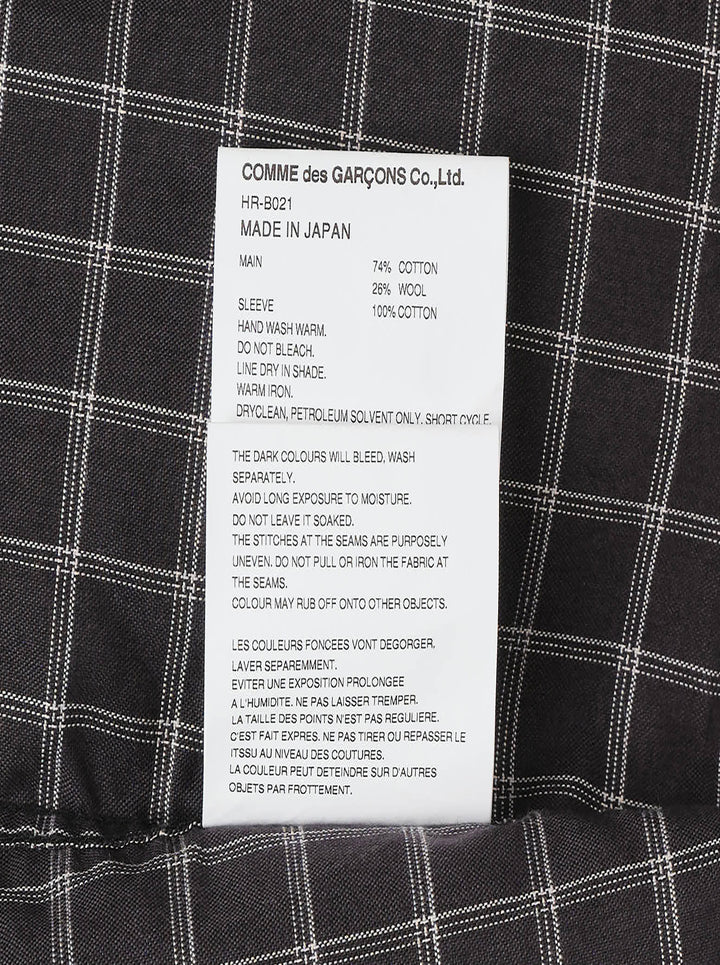 Comme des Garçons Homme long sleeve shirt with dark windowpane check cotton body and contrast solid black cotton broad cloth sleeves, shown flat on a white background - view 4