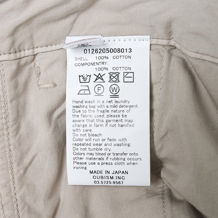 visvim Survey Damaged Pants in light stone, wide-leg silhouette with paint-splatter distressing on lower leg panels, front view on white background - view 3