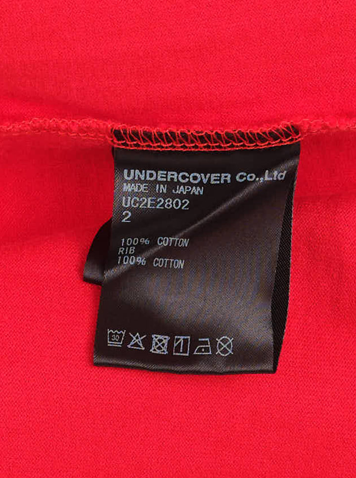 Red oversized Undercover short-sleeve tee with a blue birdcage illustration and white 'Unseen Birds' lettering on the chest - view 3