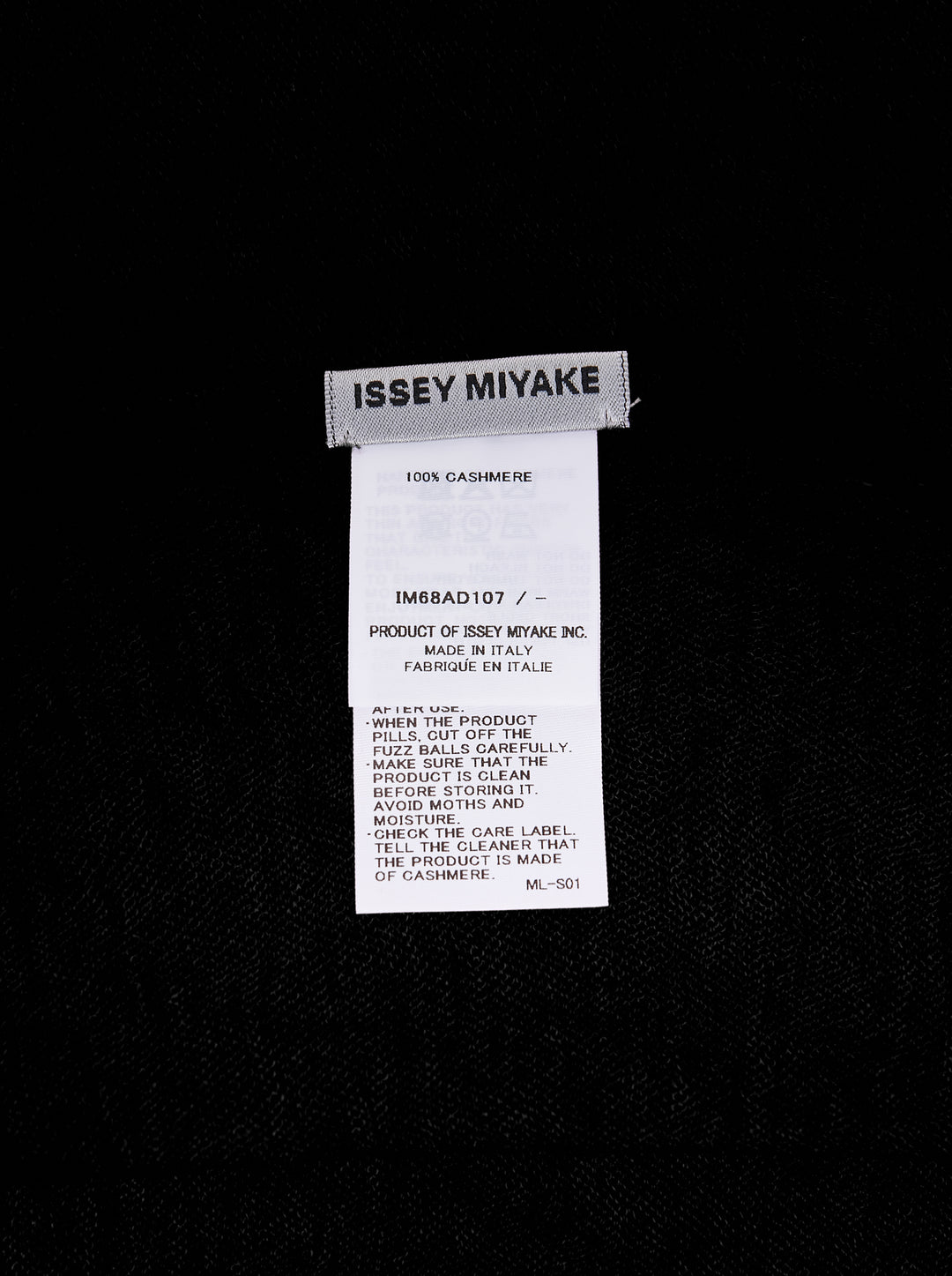 Issey Miyake black cashmere knit stole laid flat, showing frayed edges and woven brand label - view 2