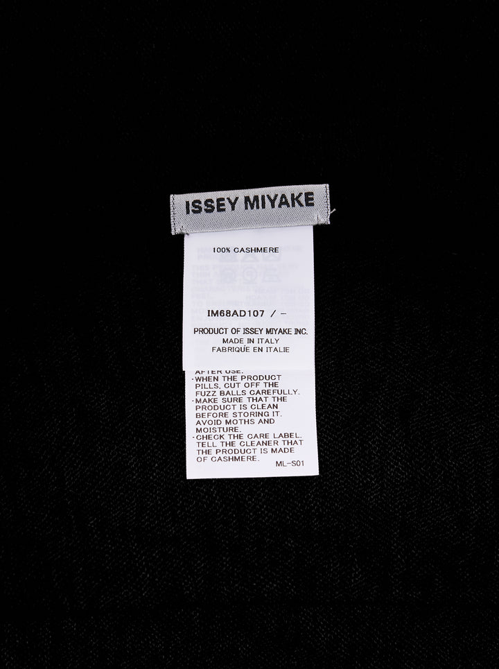 Issey Miyake black cashmere knit stole laid flat, showing frayed edges and woven brand label - view 2