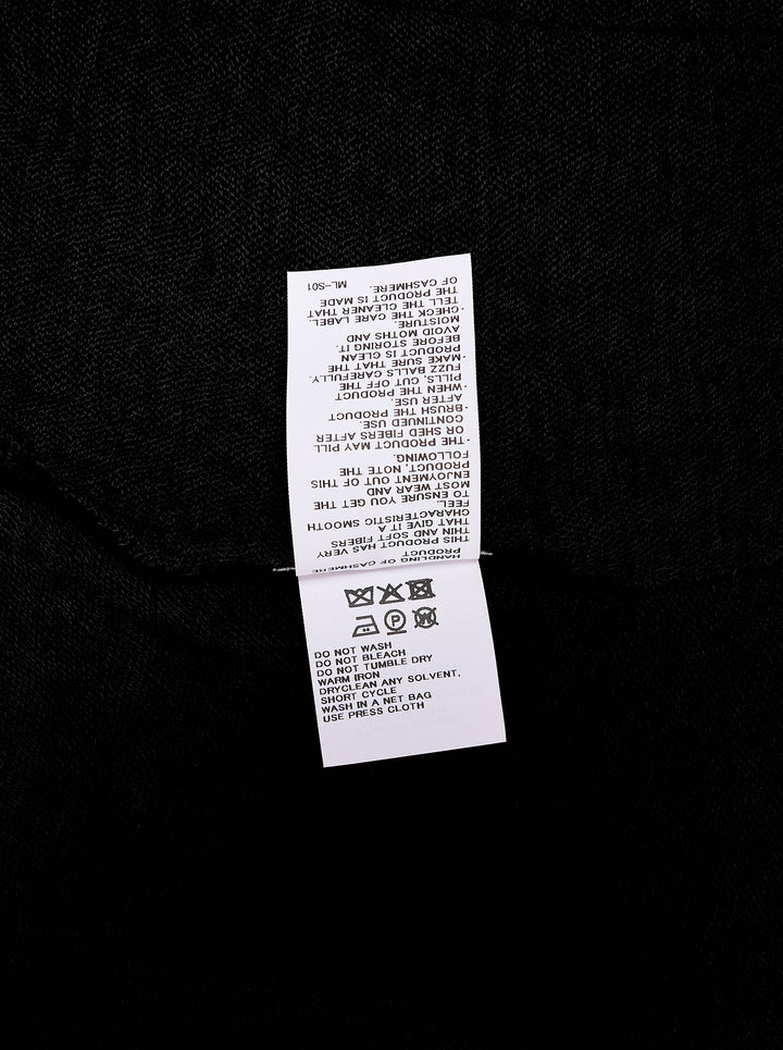Issey Miyake black cashmere knit stole laid flat, showing frayed edges and woven brand label - view 3