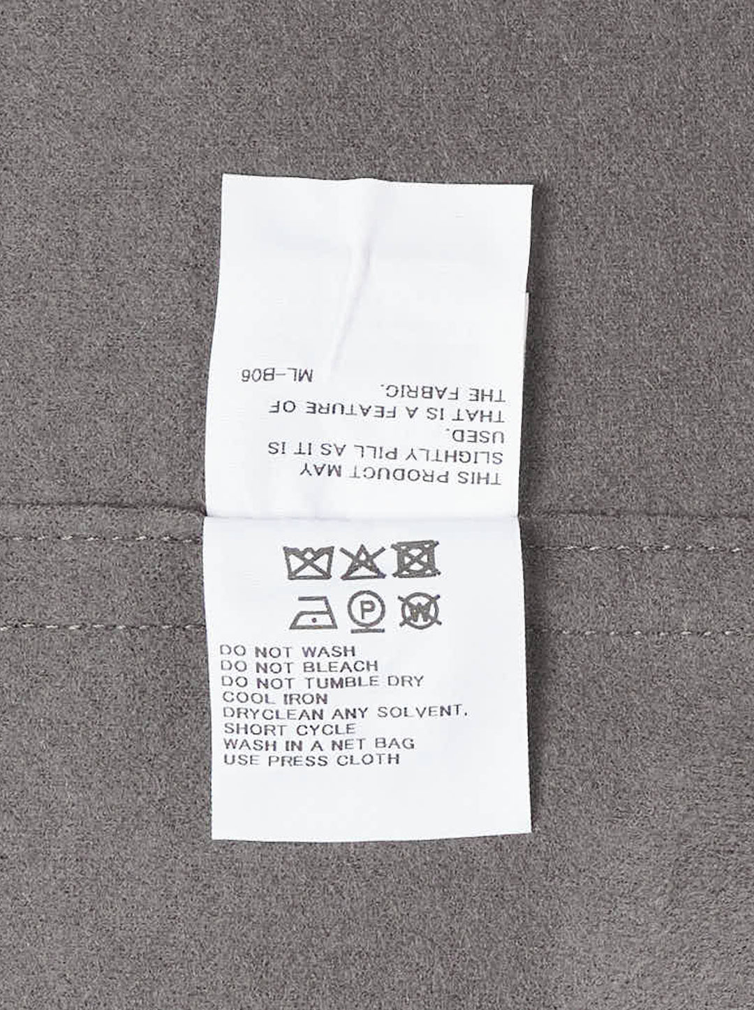 Issey Miyake CALLIGRAPH grey long-sleeve wrap jacket with asymmetric diagonal drape panels, side buckle fastening, and curved hem, displayed flat on white background - view 3
